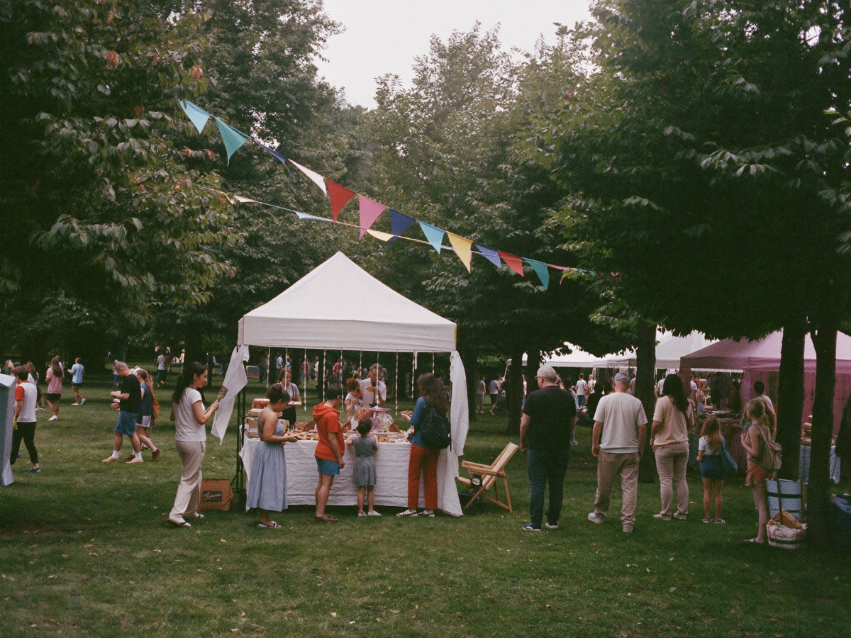 A summer fair with bunting and stalls on a village green
